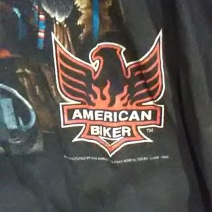 a shirt with two people on a  bike with a Indian skill behind them.
